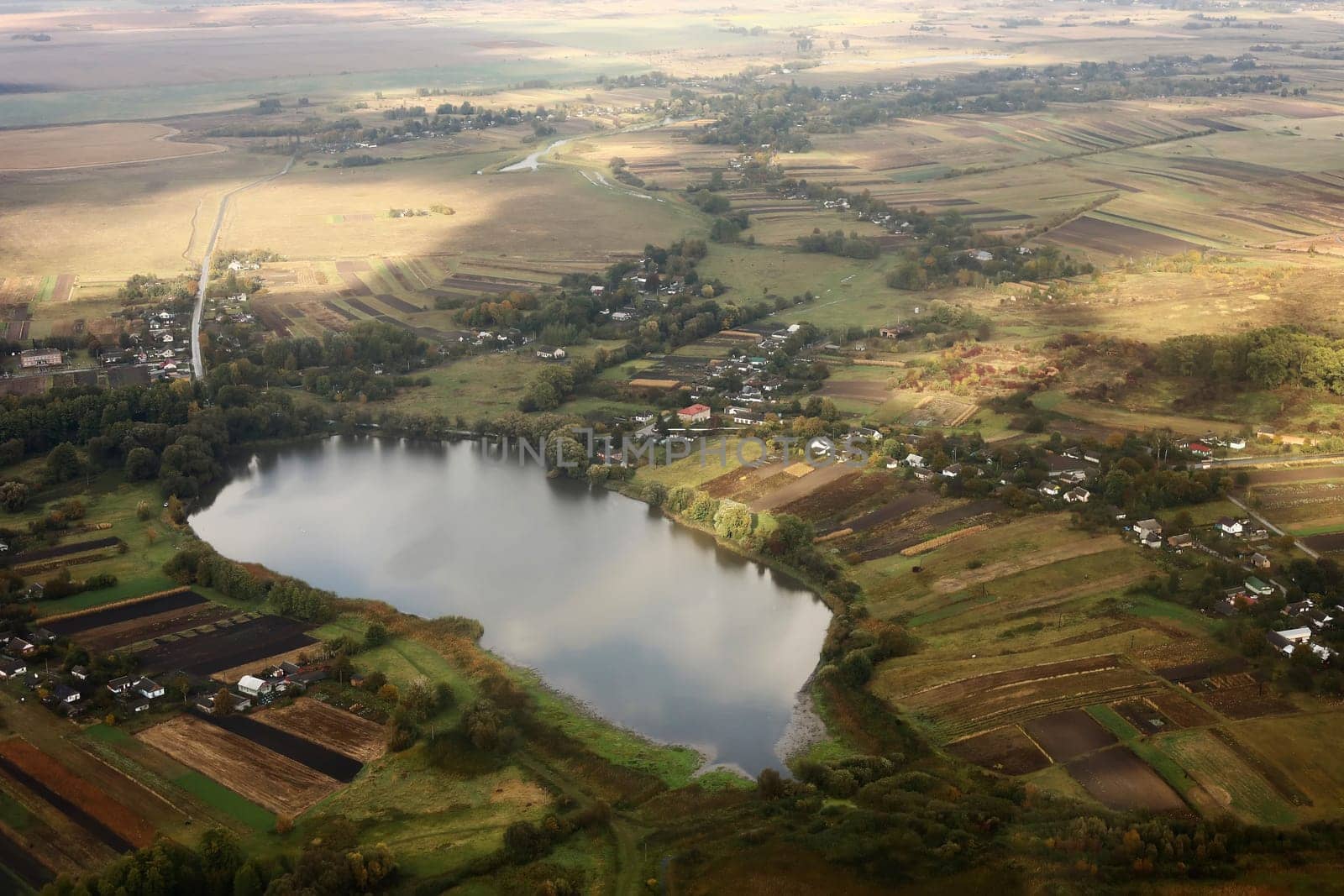 view of the village from the sky. photo with noise. Aerial view of farmland area landscape and lake from airplane. Landscape with lake. Environment protection. Drone flight