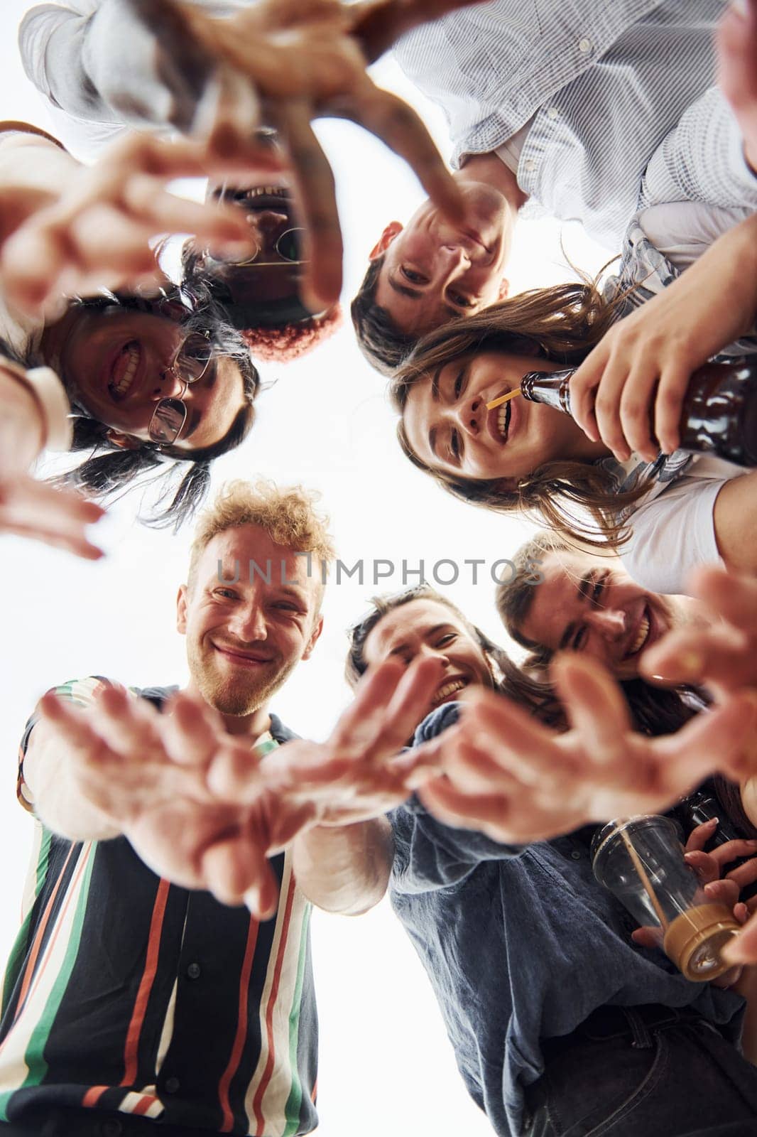 Looking down. View from below. Group of young people in casual clothes have a party at rooftop together at daytime by Standret