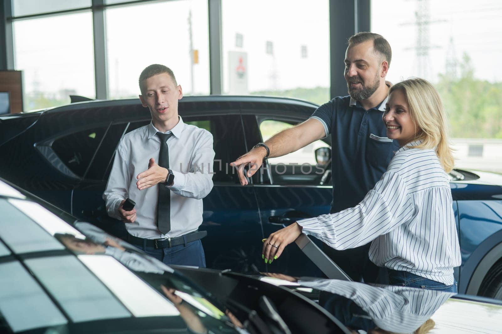 Happy caucasian couple choosing a new car in a car dealership. by mrwed54