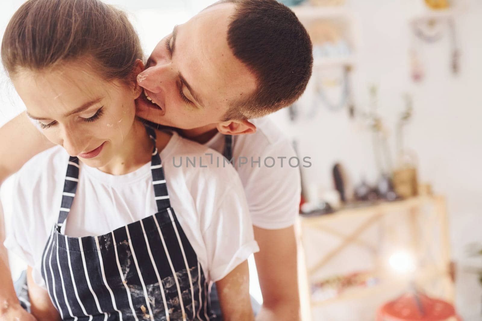 With her boyfriend or husband. Close up view of young female ceramist that indoors with handmade clay product. Conception of pottery.