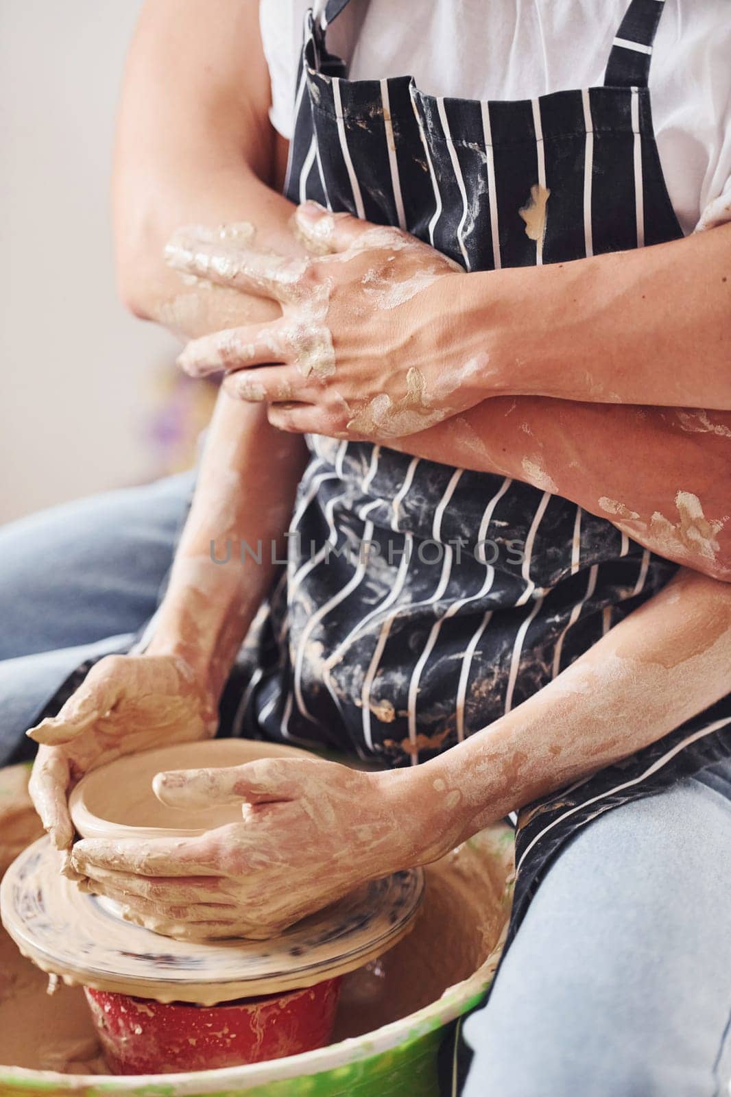 With her boyfriend or husband. Close up view of young female ceramist that indoors with handmade clay product. Conception of pottery.