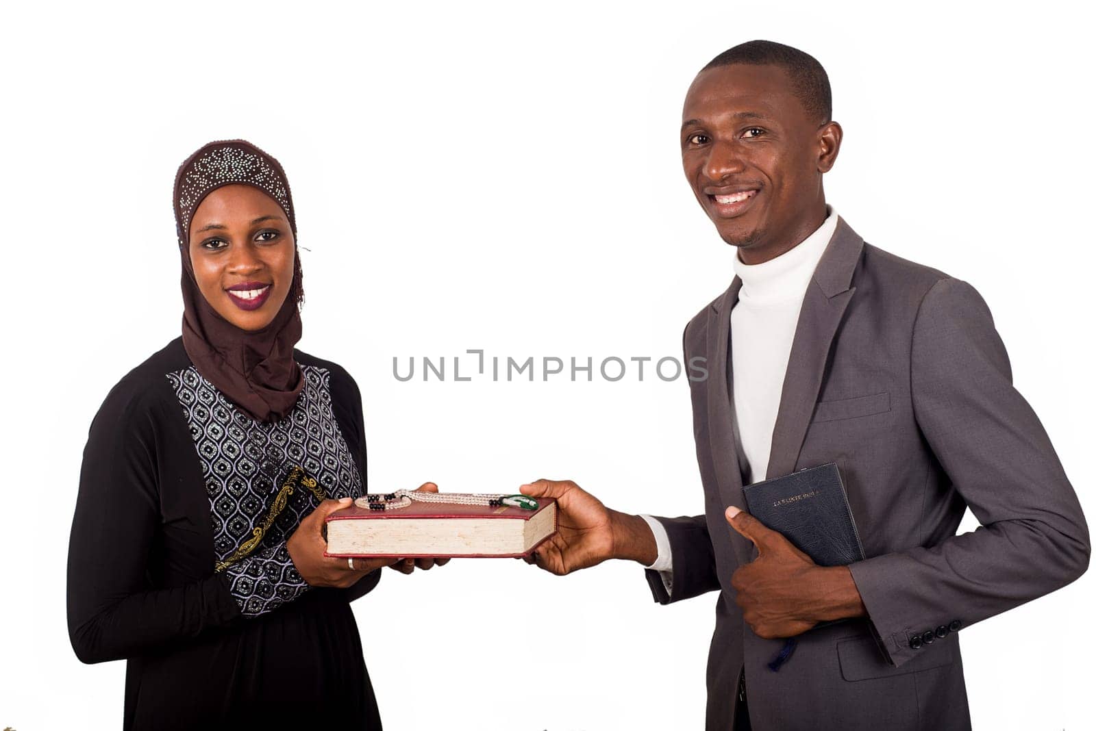 portraits of two smiling religious people holding a book on white background and looking at the camera