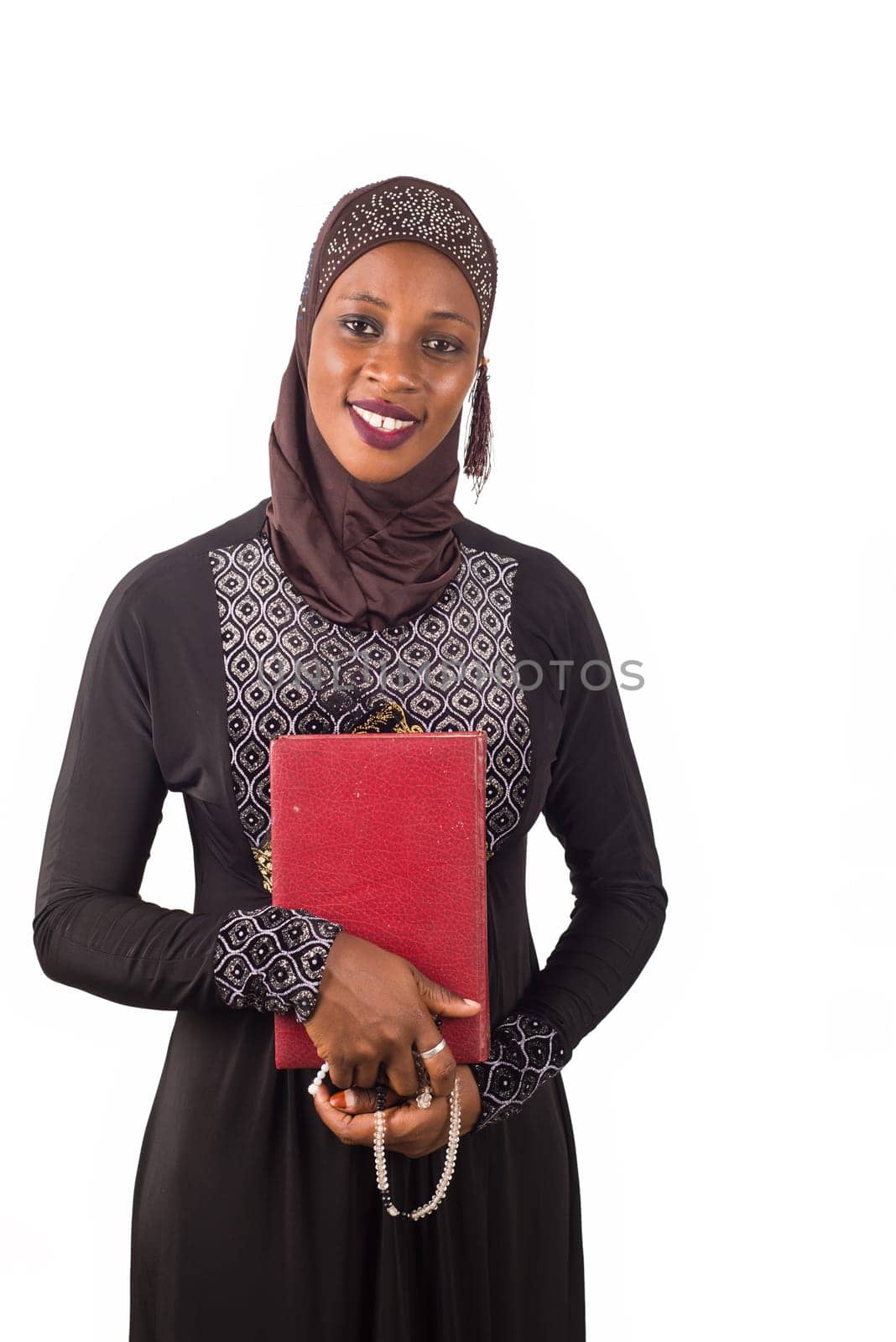 portrait of young muslim woman standing and holding a religious document on white background.