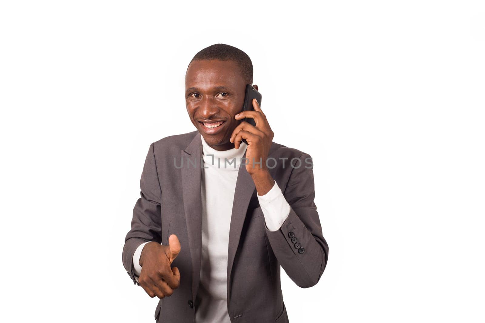 portrait of young smiling man in suit standing phoning isolated on white background.