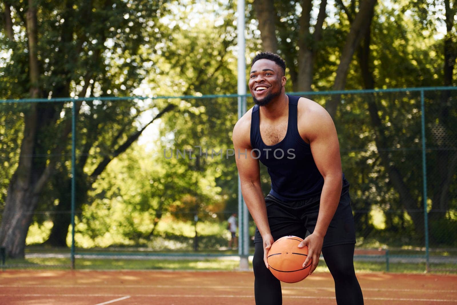 African american man with girl plays basketball on the court outdoors by Standret