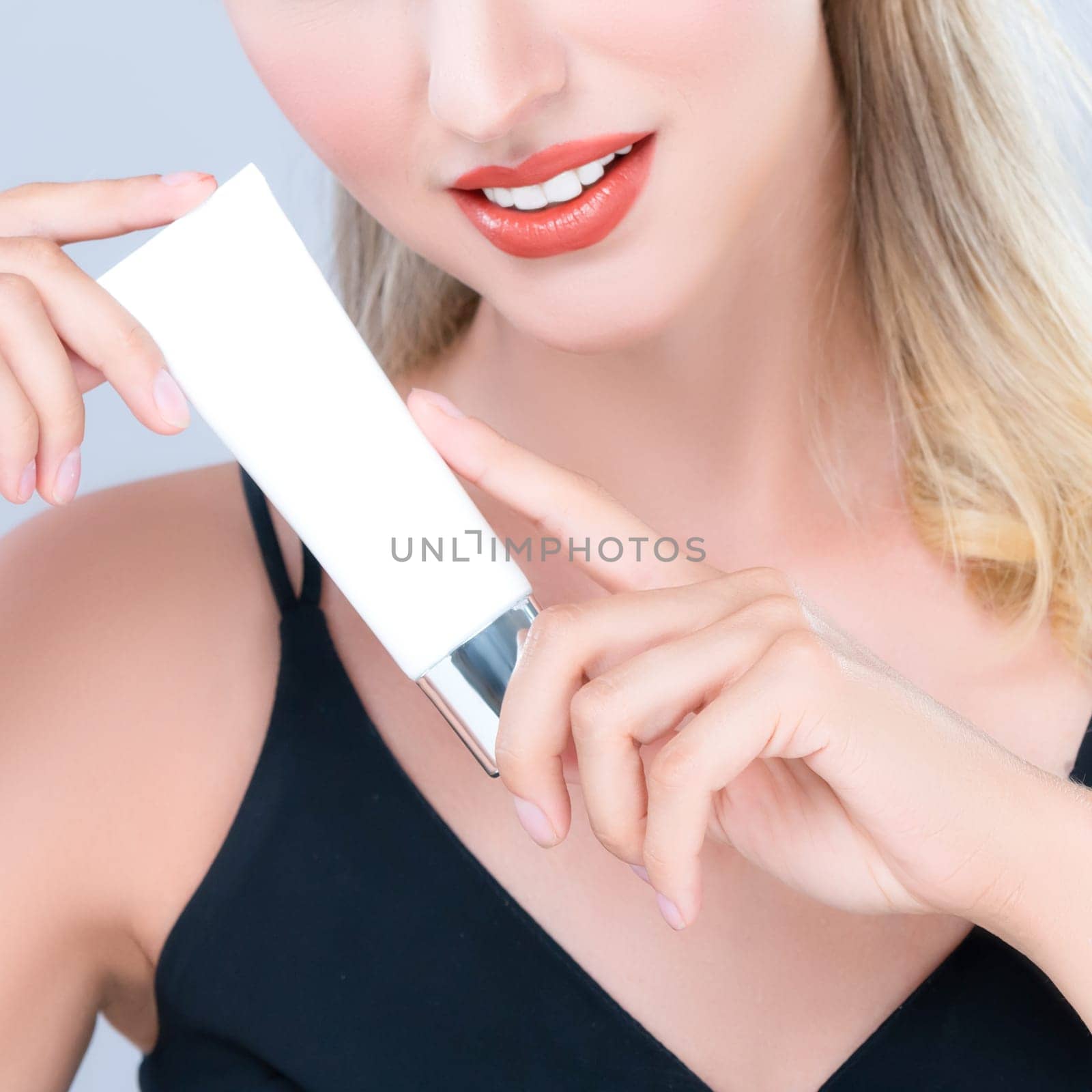 Closeup alluring portrait of perfect skin woman holding mockup moisturizer tube. by biancoblue