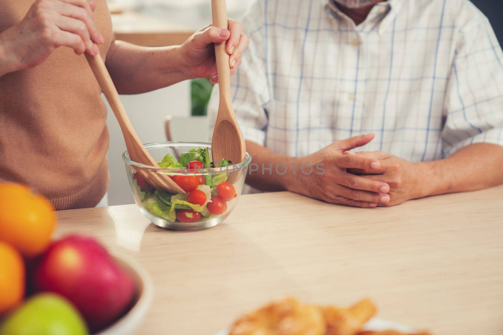 Contented senior couples who are happy to cook together with bread veggies and fruit in their kitchen.