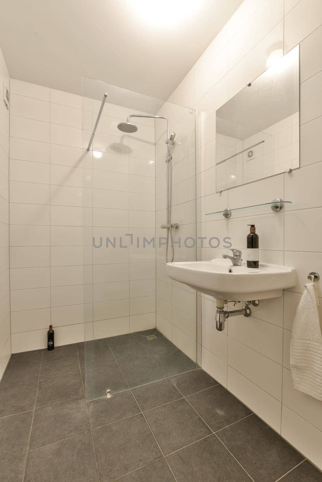 a bathroom with a sink, mirror and shower head mounted on the wall next to it is a towel rack