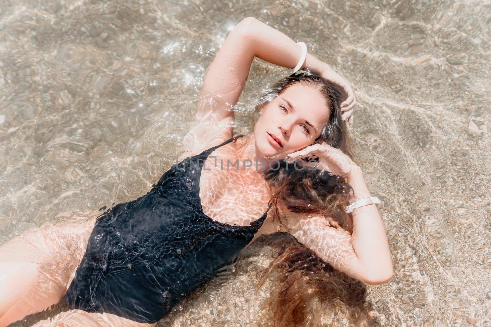 Woman summer travel sea. Happy tourist enjoy taking picture outdoors for memories. Woman traveler posing on the beach at sea surrounded by volcanic mountains, sharing travel adventure journey by panophotograph