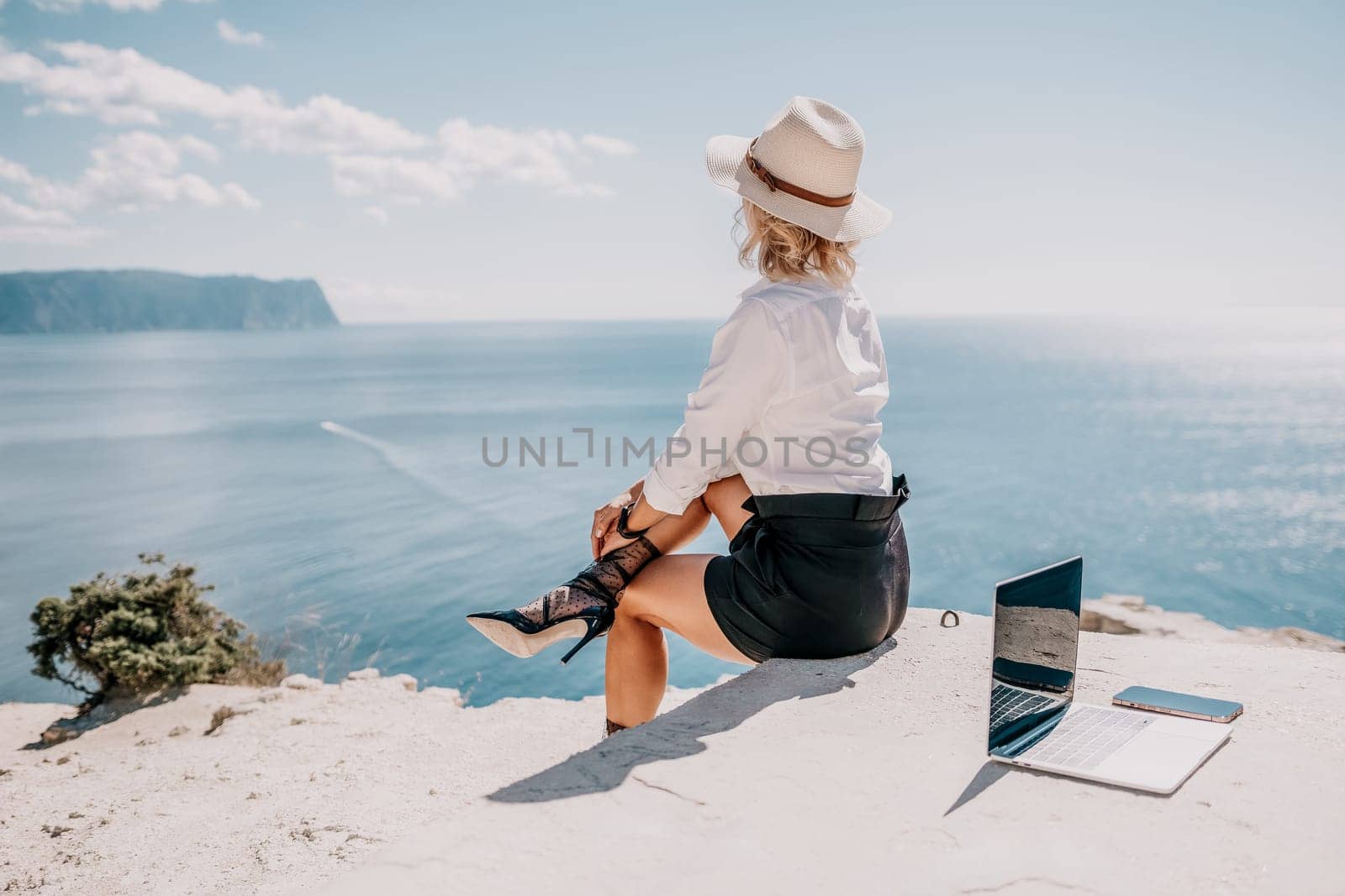 Happy girl doing yoga with laptop working at the beach. beautiful and calm business woman sitting with a laptop in a summer cafe in the lotus position meditating and relaxing. freelance girl remote work beach paradise