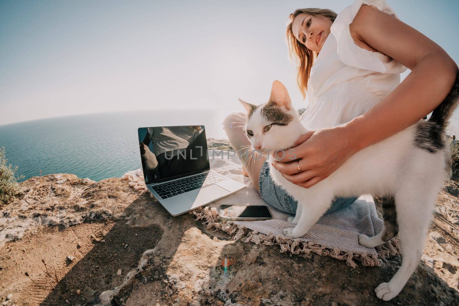 Woman sea laptop. Business woman in yellow hat working on laptop by sea. Close up on hands of pretty lady typing on computer outdoors summer day. Freelance, digital nomad, travel and holidays concept.