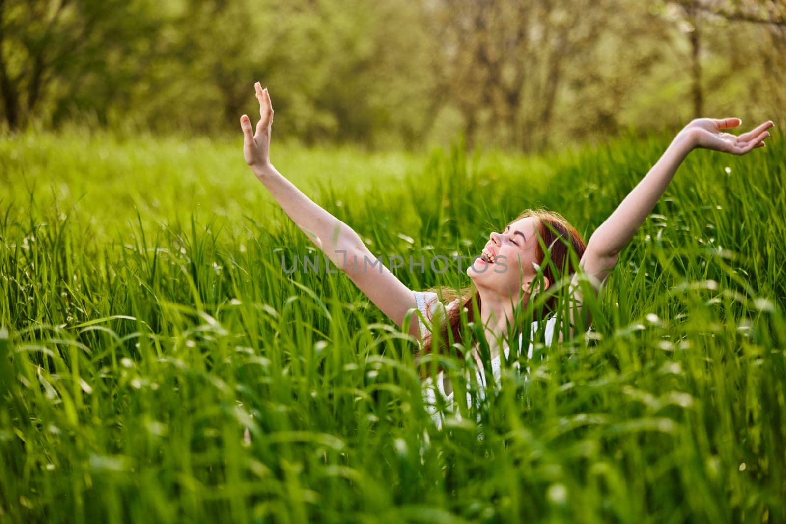 a woman rejoices in a summer day and raises her hands enthusiastically. High quality photo