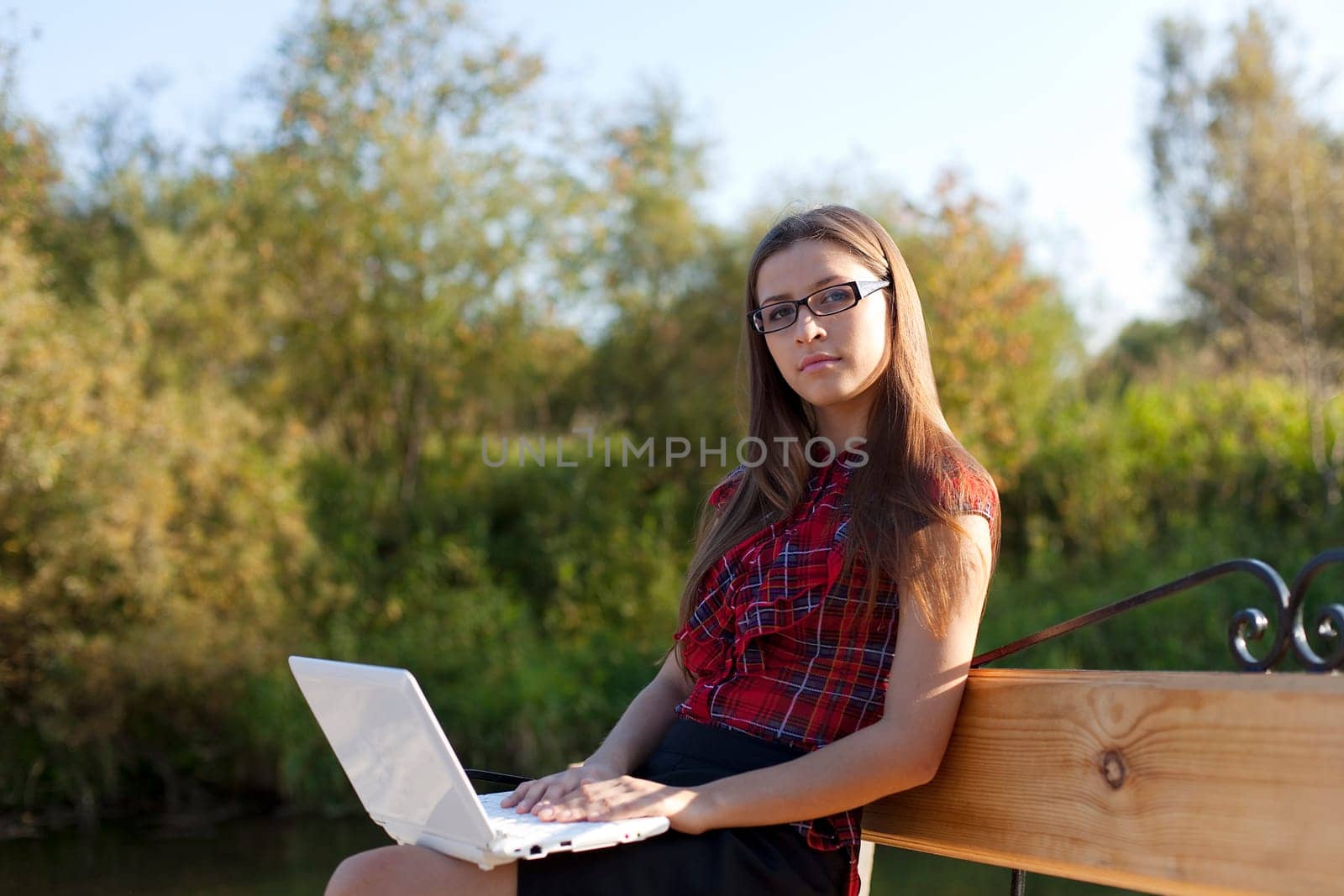 Girl on bench work with laptop in autumn park