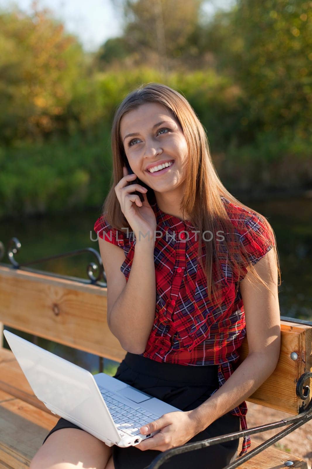 Woman on bench work with laptop and call phone