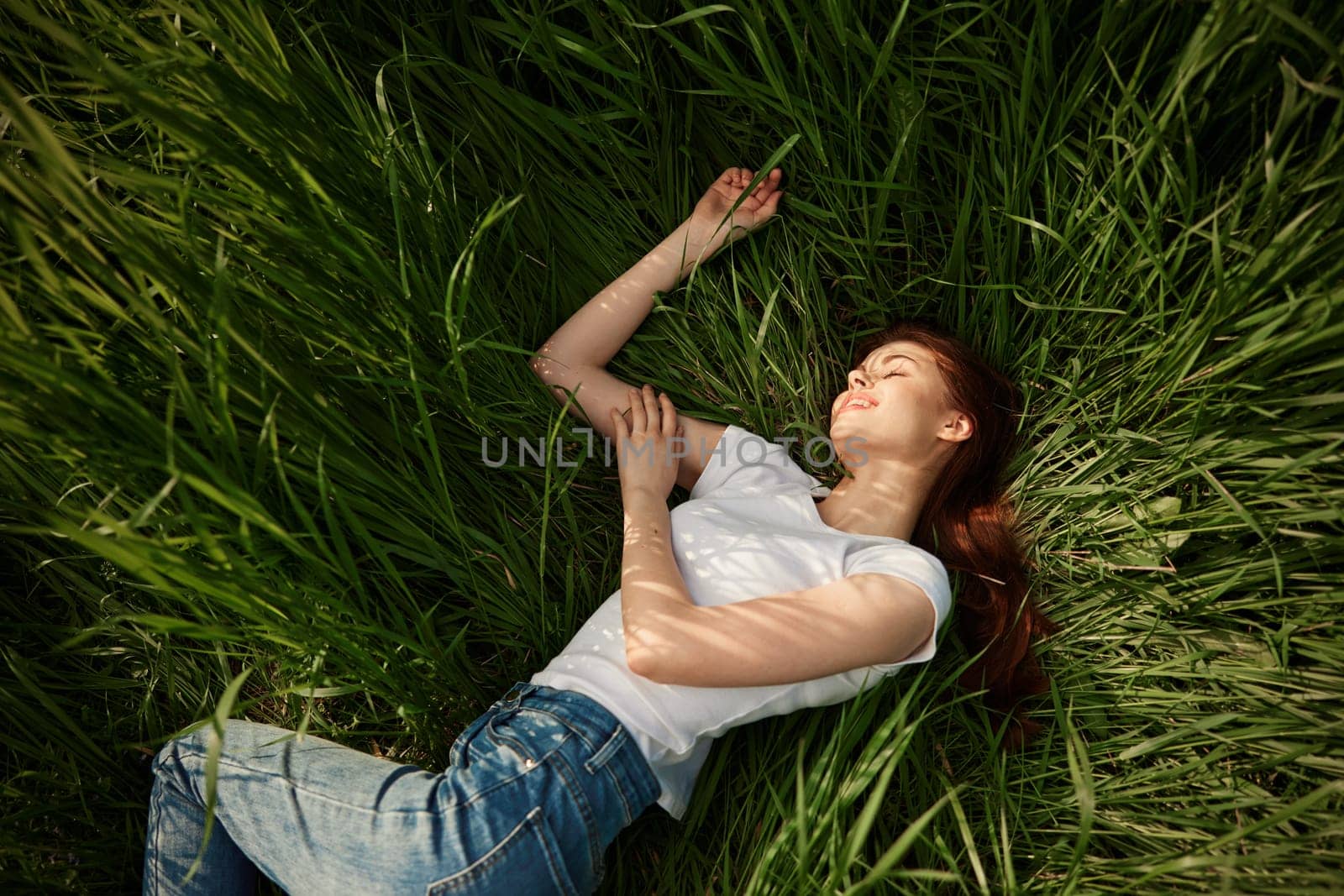 woman resting from worries lying in tall grass by Vichizh