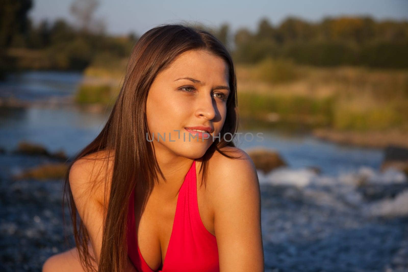 Young beauty woman in red look at sunset - nature background