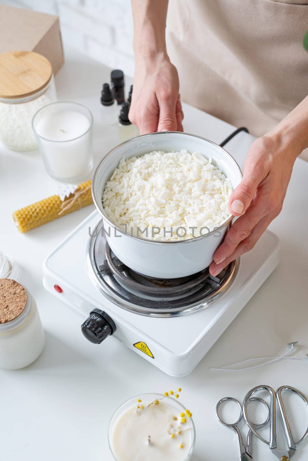 Woman making decorative aroma candles from soy wax by Desperada