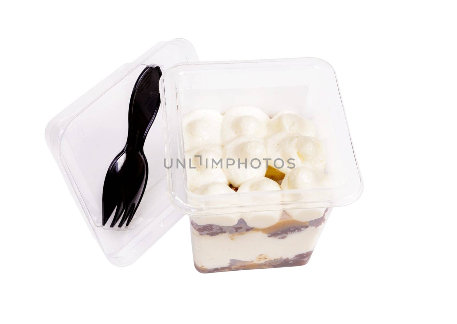 Portion of chocolate caramel mousse in a plastic cup with a fork on the lid on a white background. High quality photo