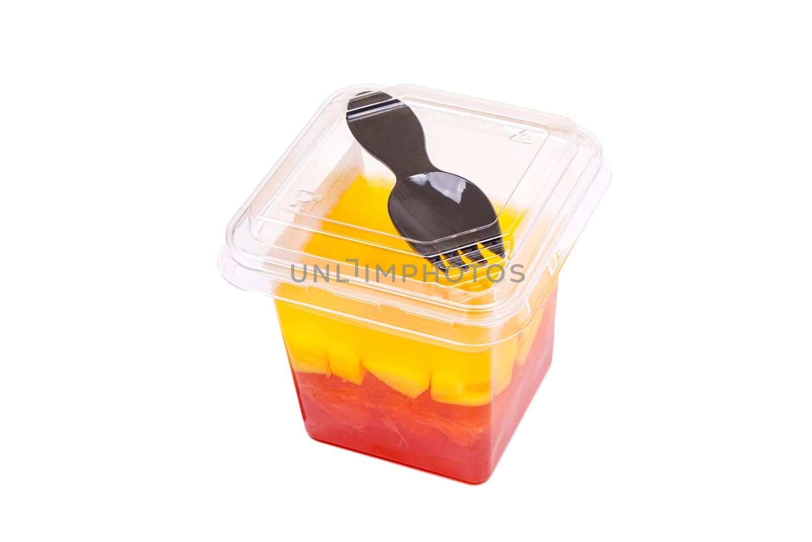 Grapefruit, mango and raspberry jelly in a plastic cup with a fork on the lid, on a white background. High quality photo