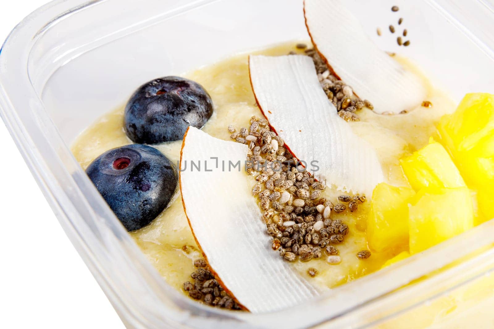 Smoothies with fresh fruits and nuts. Pineapple puree, banana. Pieces of coconut with blueberries. Close-up. High quality photo