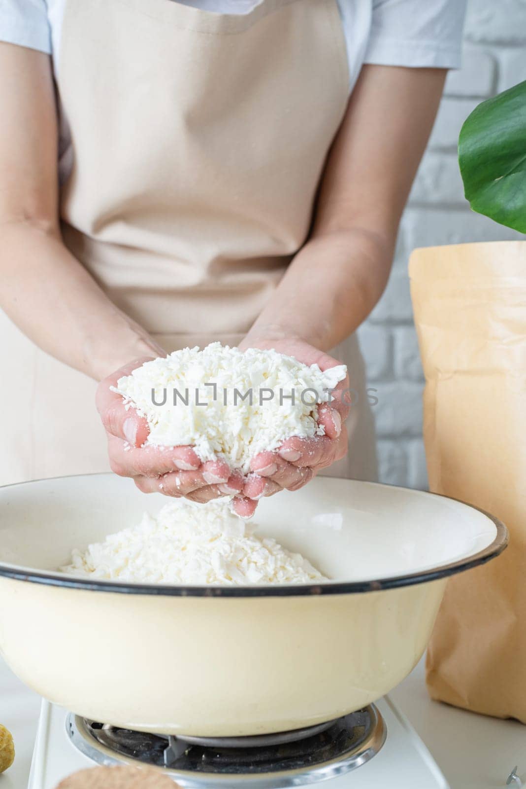 Woman making decorative aroma candles from soy wax by Desperada