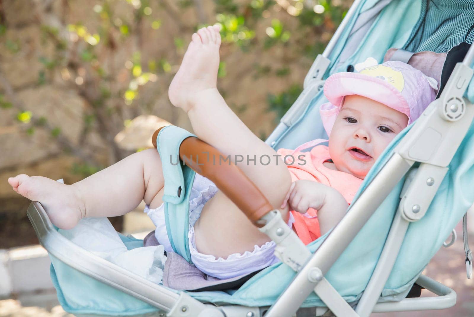 charming newborn baby girl in blue baby carriage.