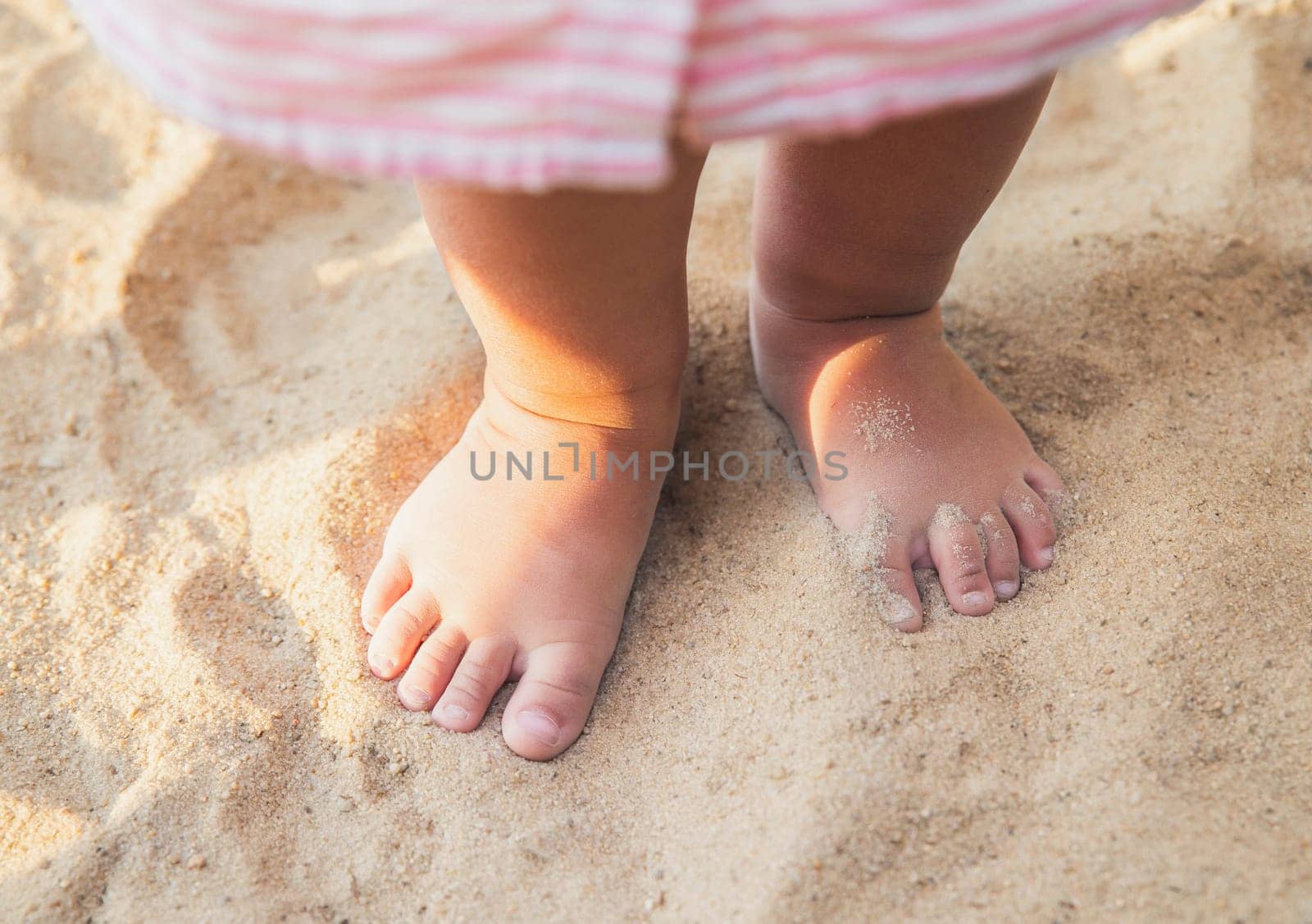 little baby feet of a child who walks along the seashore.