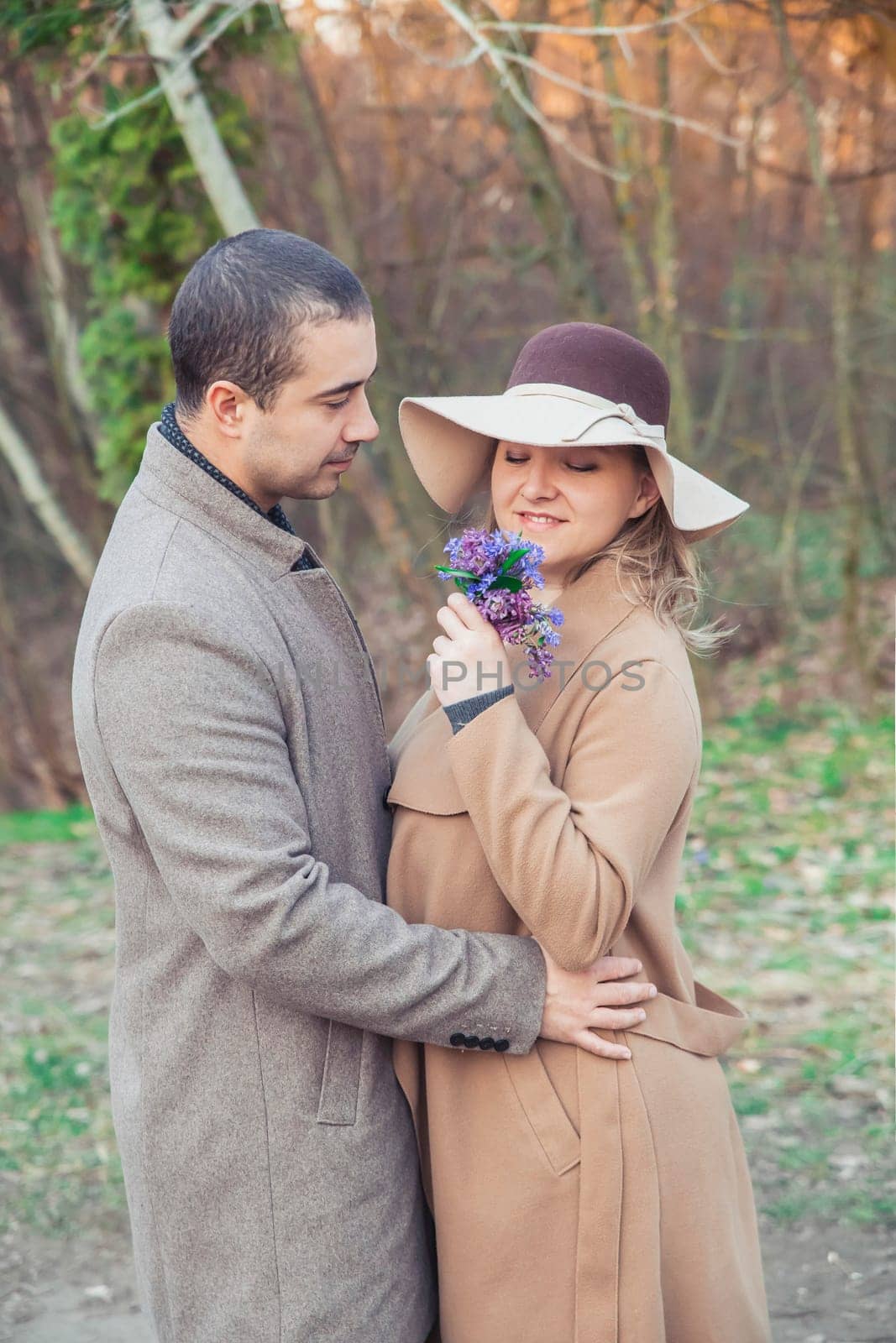 Man gives his wife flowers in autumn park.