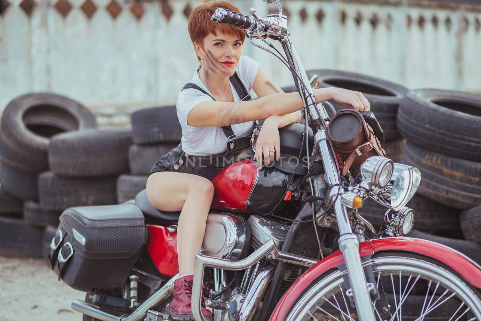 Beautiful slim woman smiling on a motorcycle.
