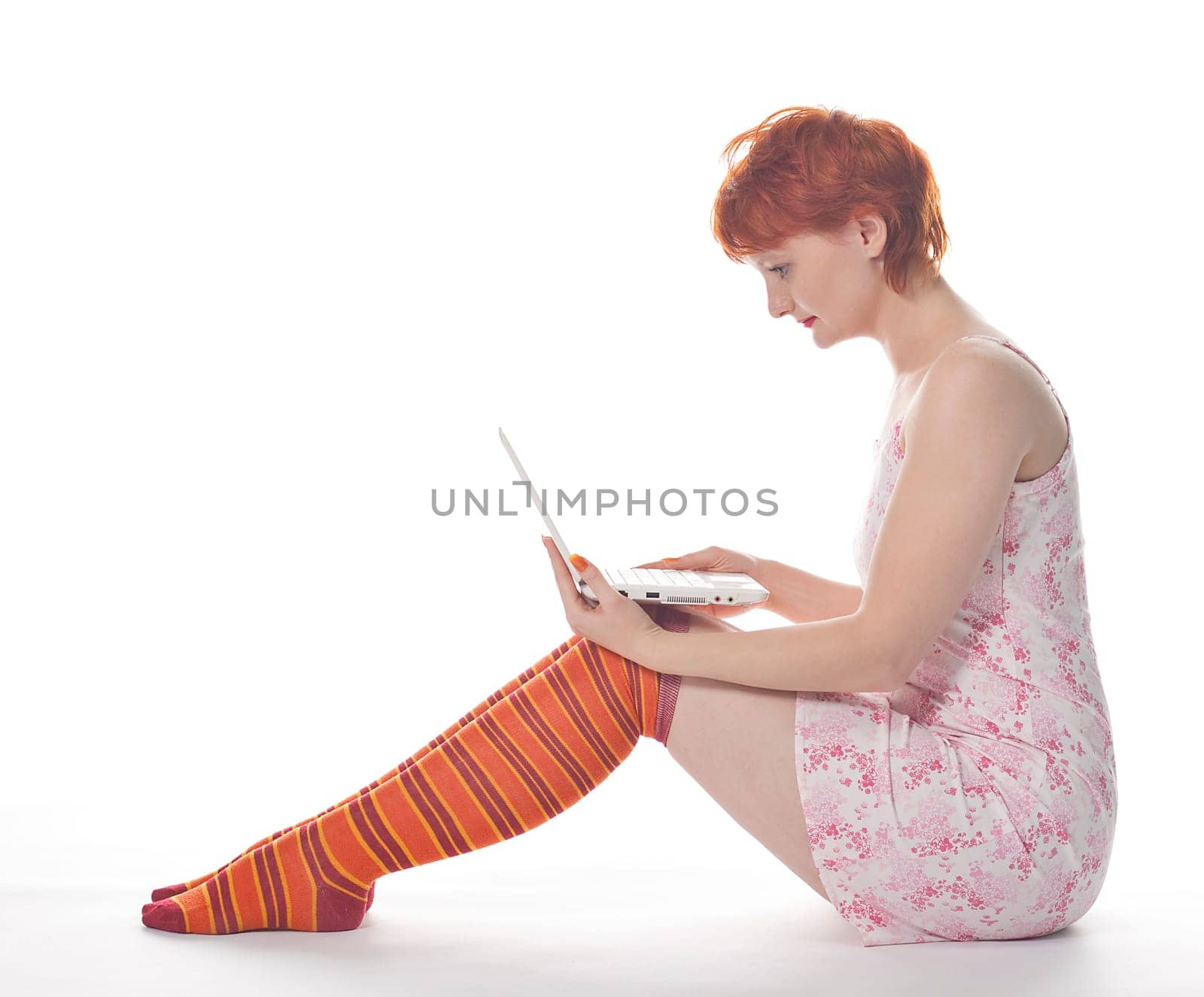 Red Girl in stripe socks with laptop on white background