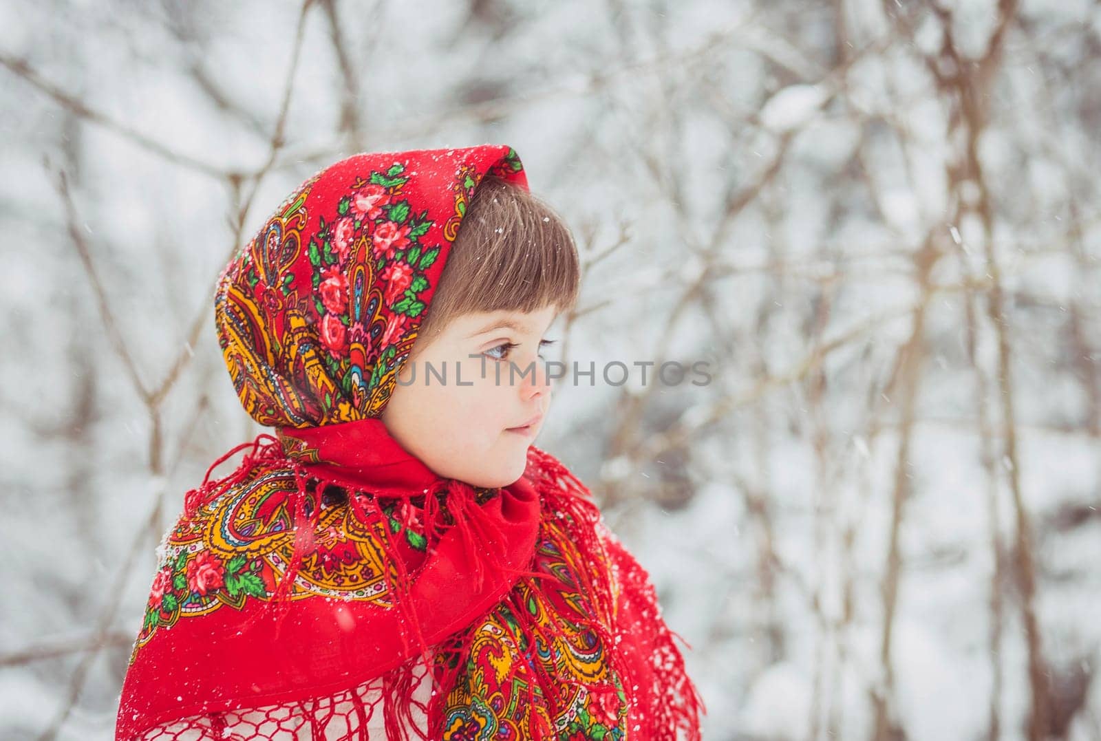 Beautiful little girl in old Russian clothes in a winter forest.