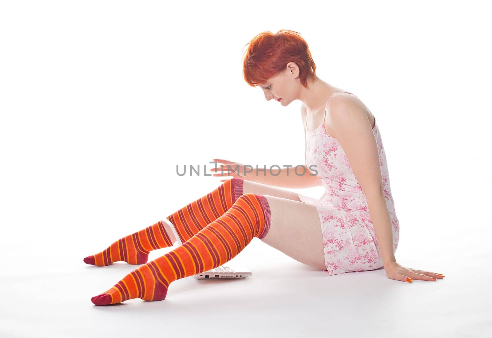 Red Girl in stripe socks with laptop on white background
