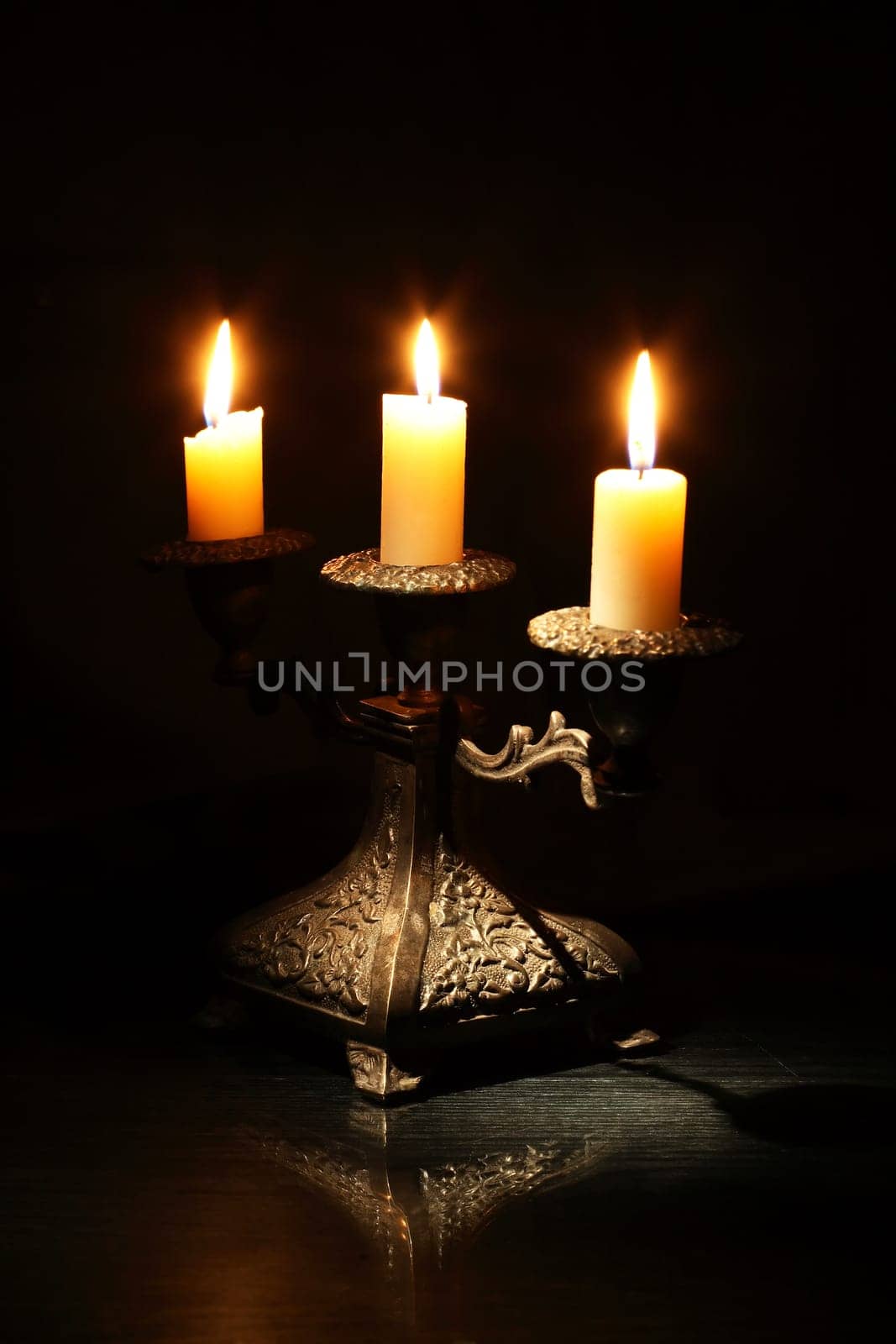 Nice vintage candlestick with lighting candles on dark background