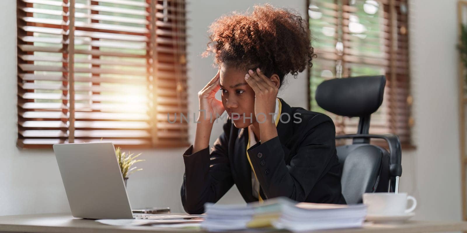 Tired American African business woman in stress works with many paperwork document. migraine attack. Freelance, work from home by itchaznong