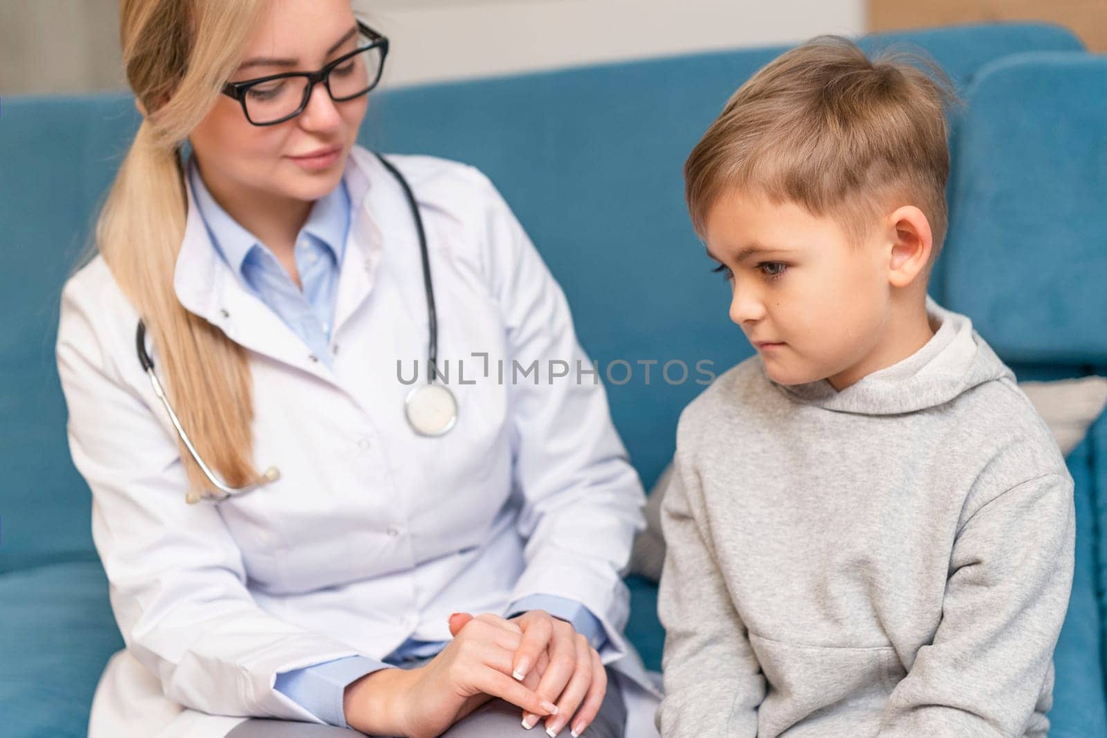 Pediatrician examines a sick child. Sick boy in the clinic. Children's home treatment of the virus.