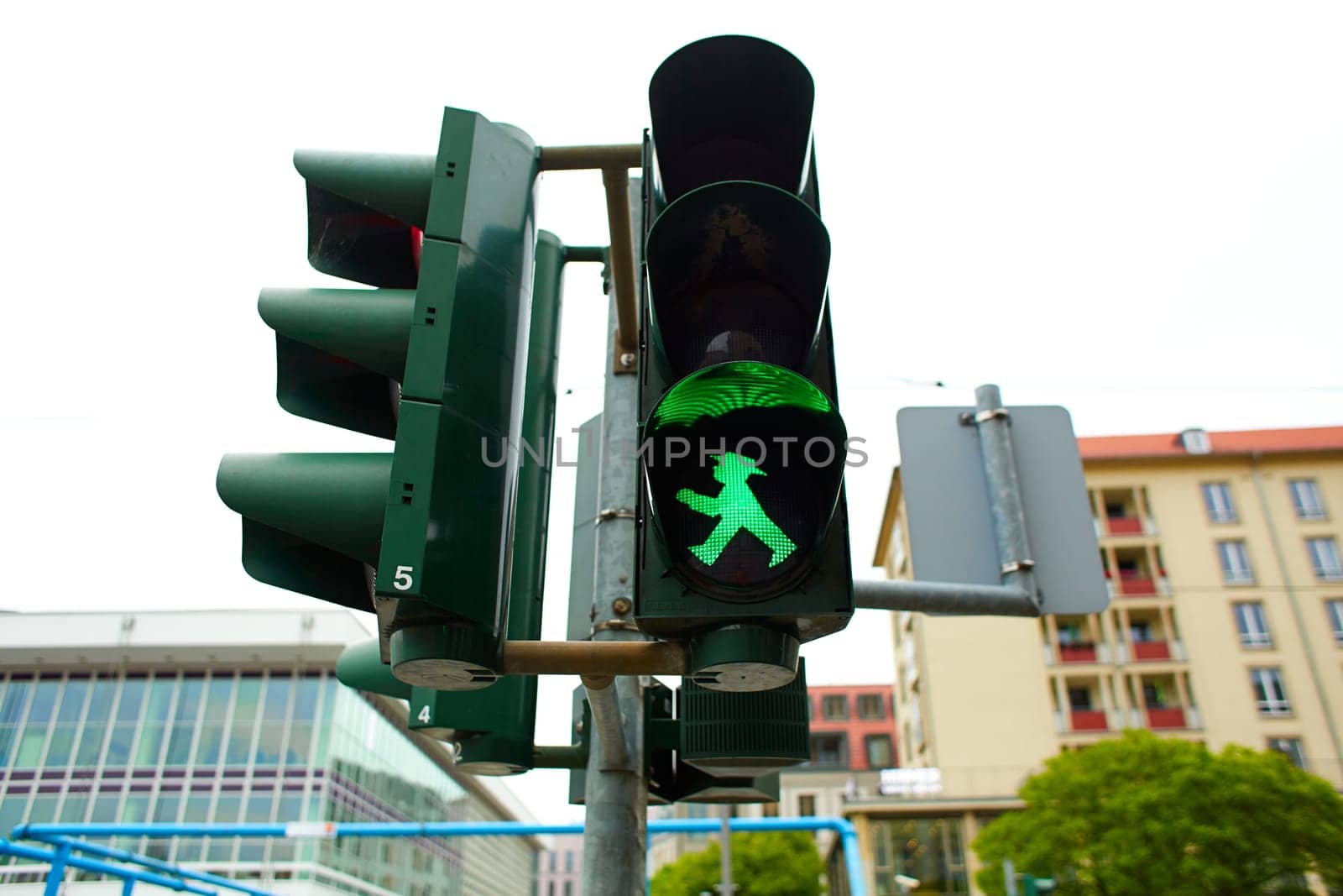 Traffic light for pedestrians with the figure of a walking man, lights green.