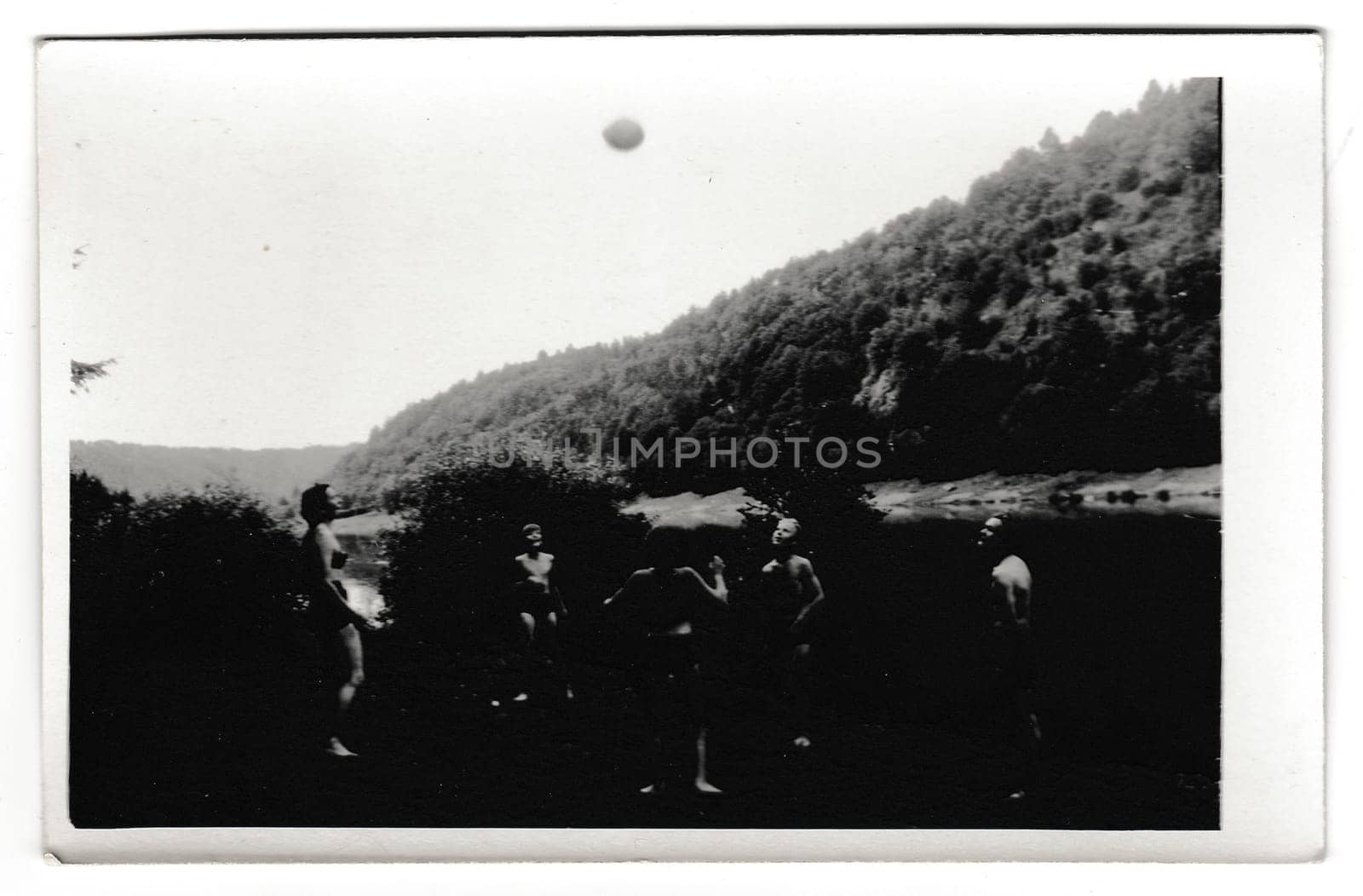 Retro photo shows people on the vacation. Young people play with ball. Summer holiday theme. Vintage black and white photography. by roman_nerud