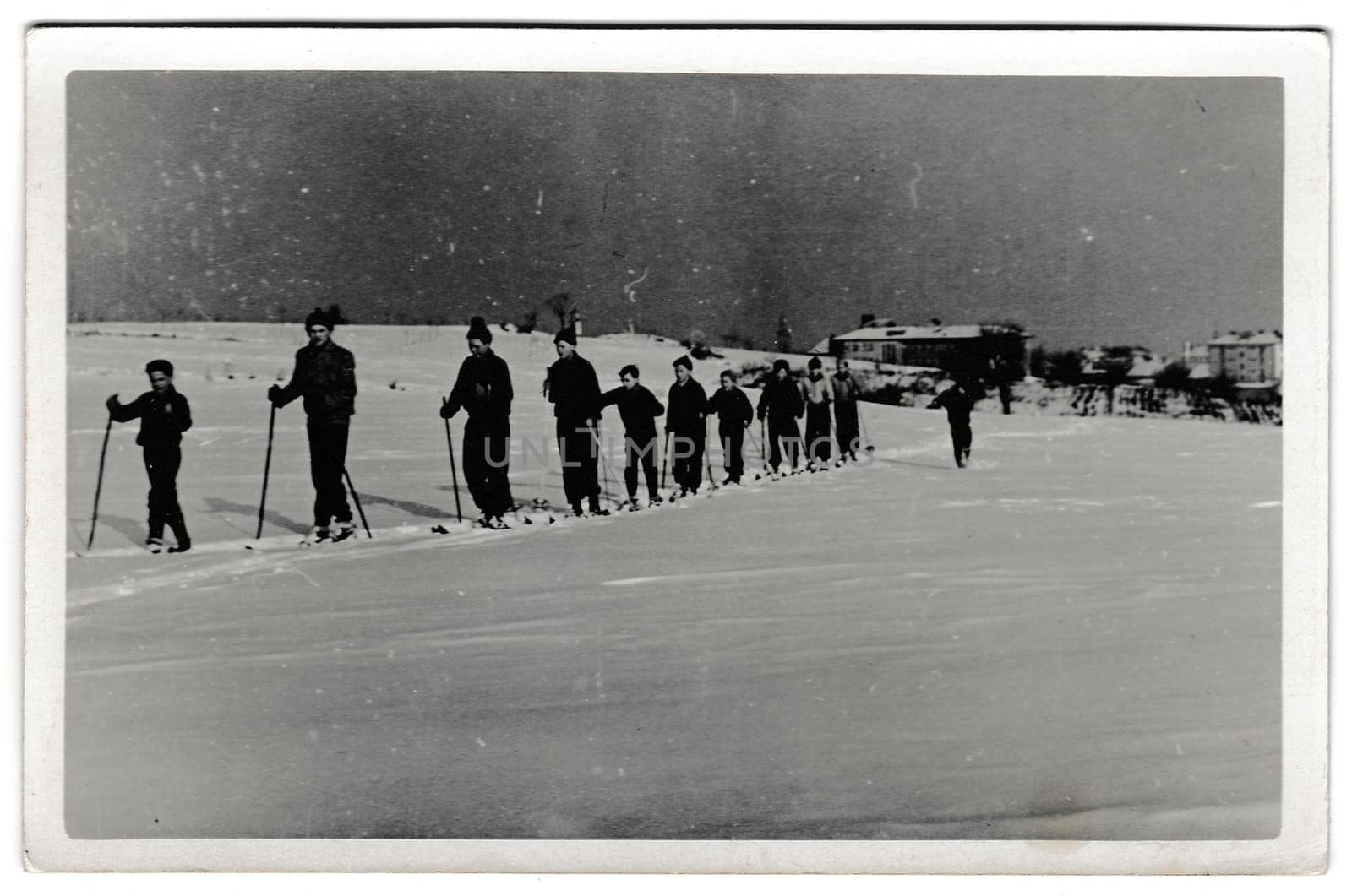 THE CZECHOSLOVAK SOCIALIST REPUBLIC - FEBRUARY 24, 1956: Retro photo shows cross-country skiers outside. Winter vacation theme. Vintage black and white photography.