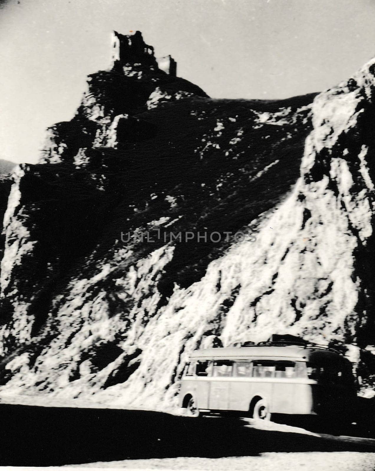 THE CZECHOSLOVAK SOCIALIST REPUBLIC - CIRCA 1950s: Retro photo shows a bus. The castle is on background. Vintage black and white photography.