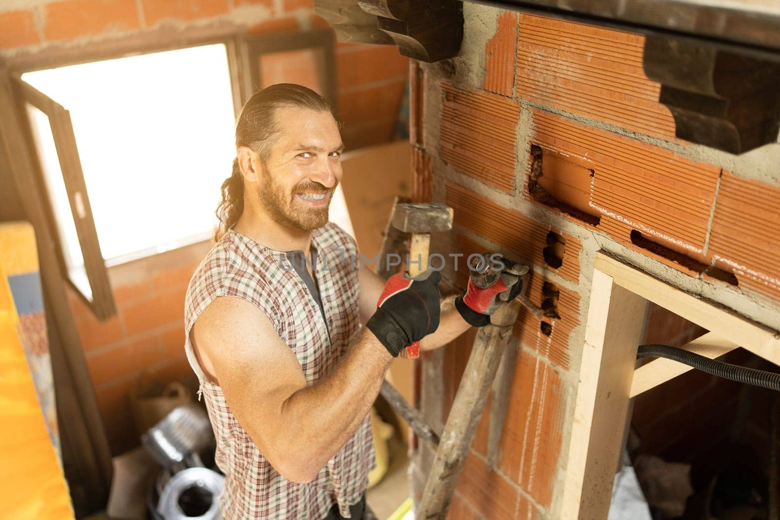 Happy man cutting a hole in the wall to put in wiring