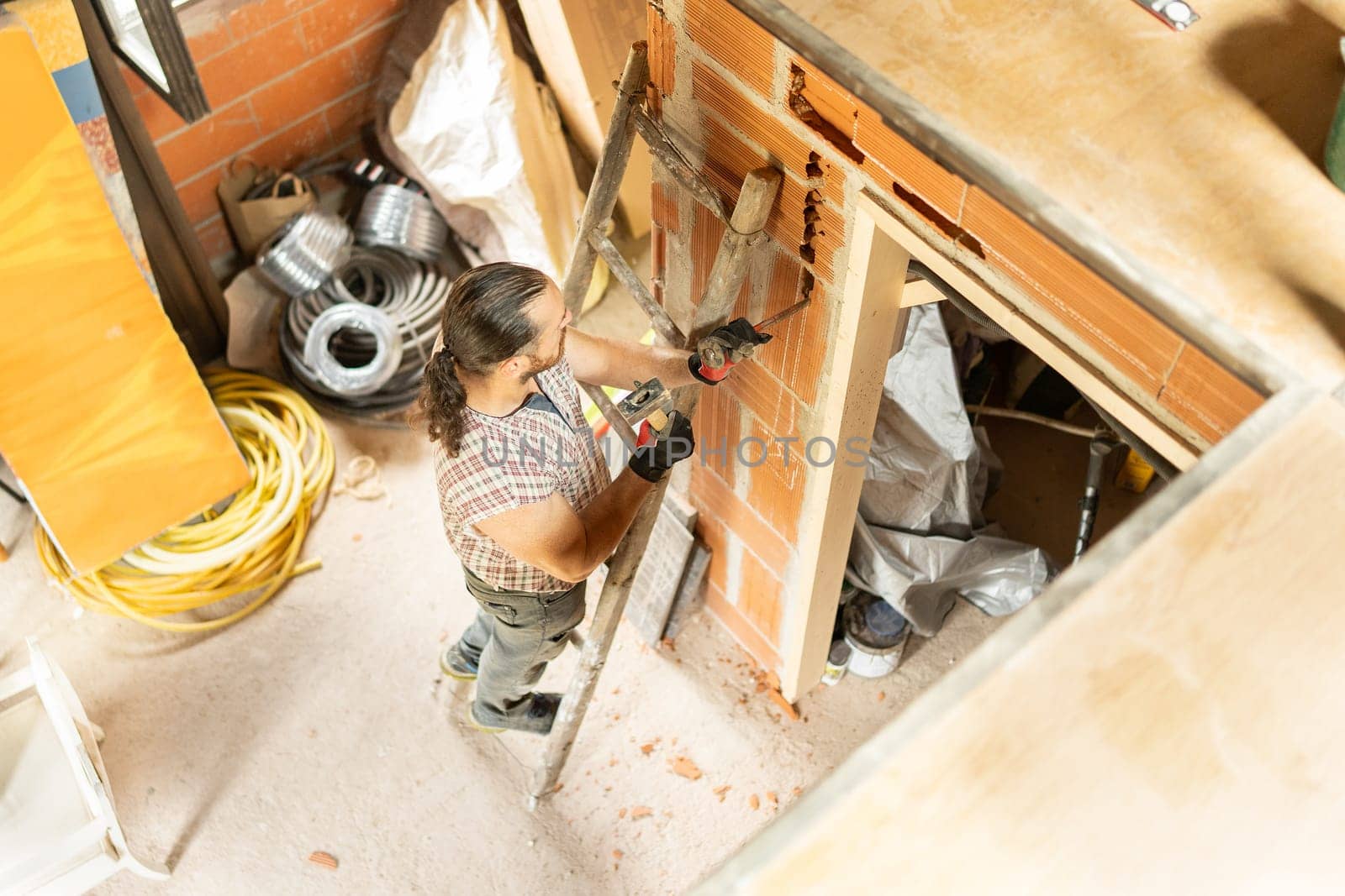 Top view of a strong man using stairs repairing a house