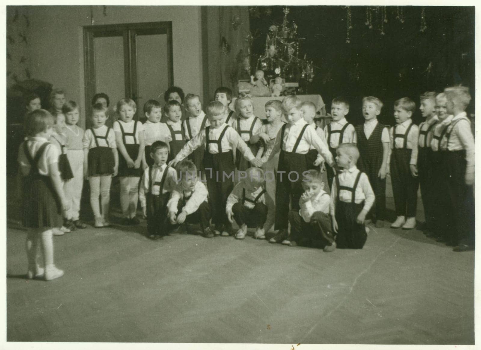 THE CZECHOSLOVAK SOCIALIST REPUBLIC - CIRCA 1960s: Retro photo shows small pupils in the classroom. Schoolmates participate in school performance during Christmas time. Vintage black and white photography.