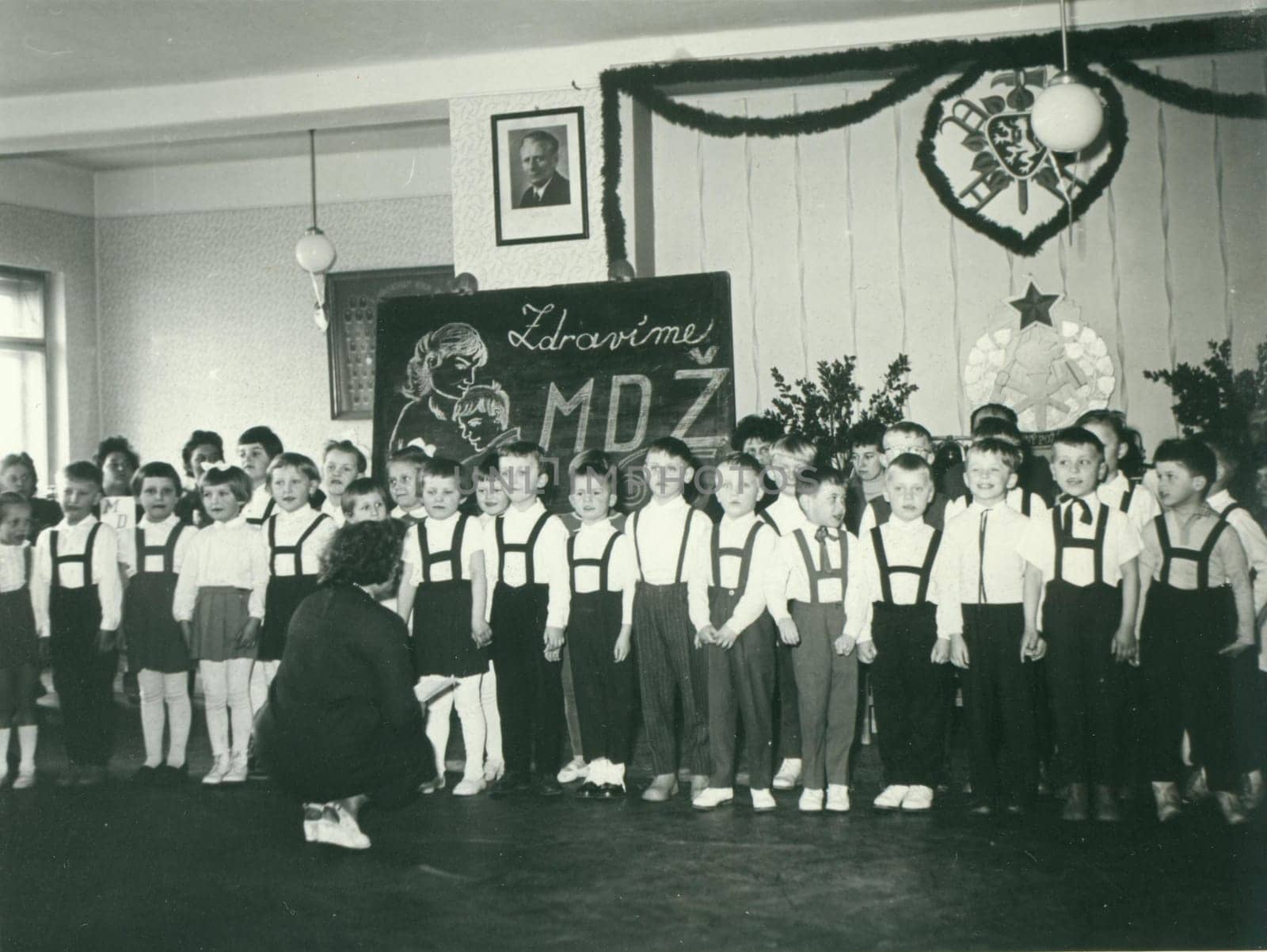 THE CZECHOSLOVAK SOCIALIST REPUBLIC - CIRCA 1960s: Retro photo shows pupils in the classroom. They celebrate International Women's Day - IWD. Vintage black and white photography.