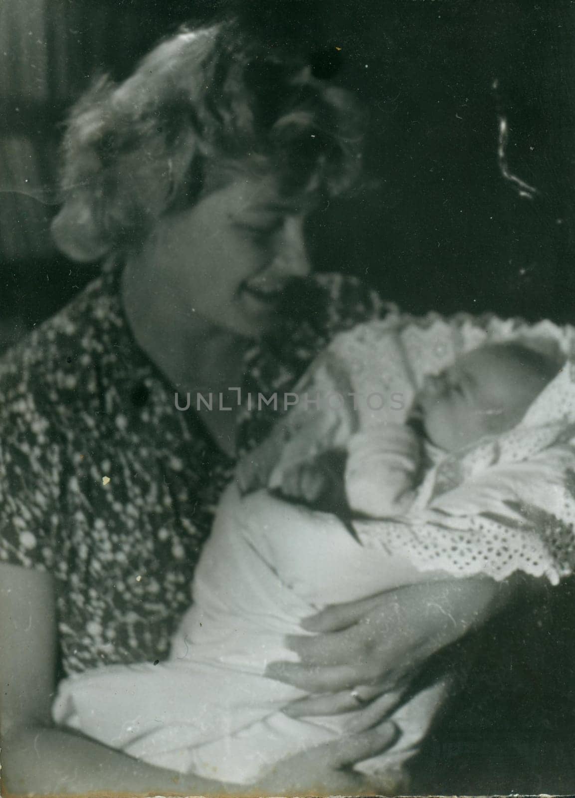 Retro photo shows woman cradles newborn baby. Vintage black and white photography. by roman_nerud