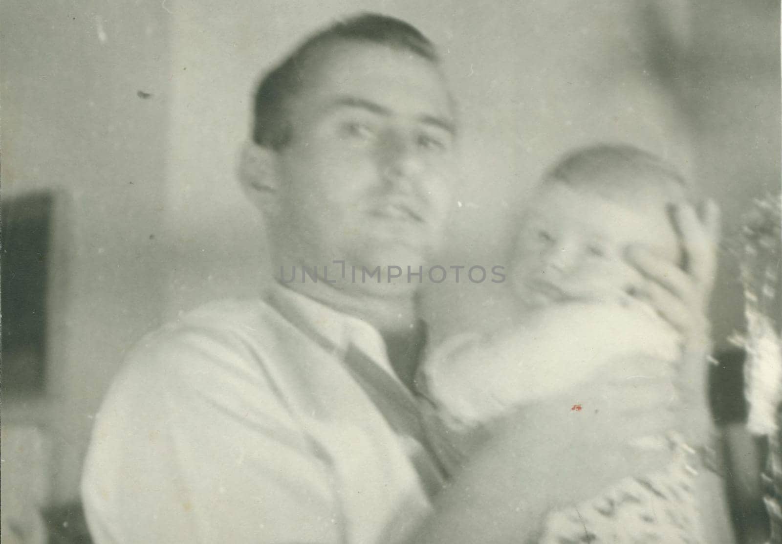 Retro photo shows newborn baby and father. Vintage black and white photography. Note: blurriness, better at smaller sizes. by roman_nerud