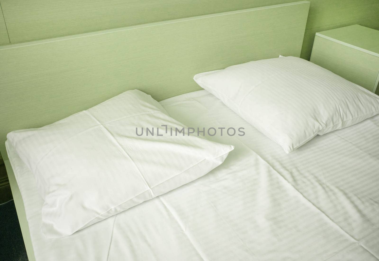 Light green tinting, close-up of white sheets and pillow in a hotel room, modern interior by claire_lucia