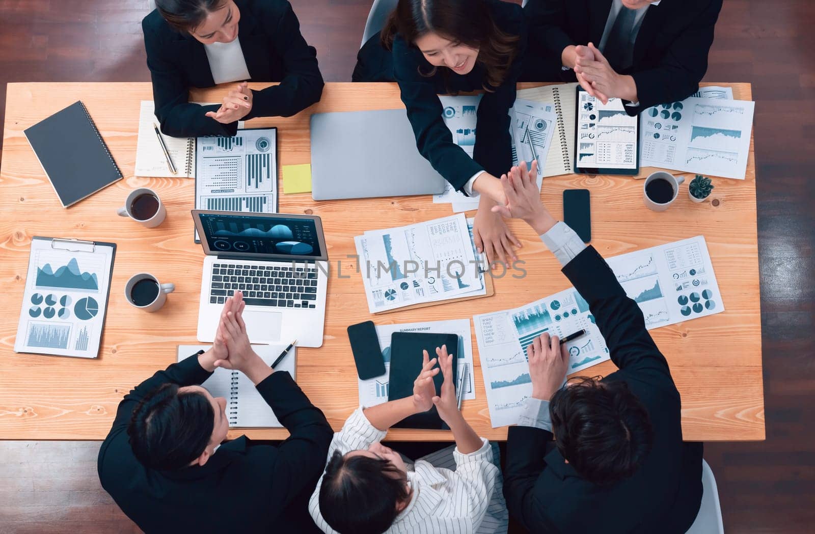 Top-view business team of financial data analysis meeting with business intelligence, report paper and dashboard on laptop for marketing strategy. Business people working together in office of harmony