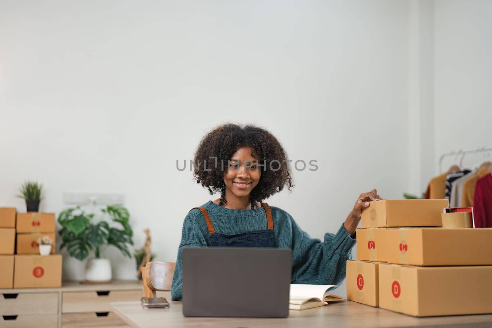 Entrepreneur, small business, SME, freelance woman working from home with lots of boxes on the side. Use smartphones and laptops for commercial monitoring. online marketing packaging box online sale.