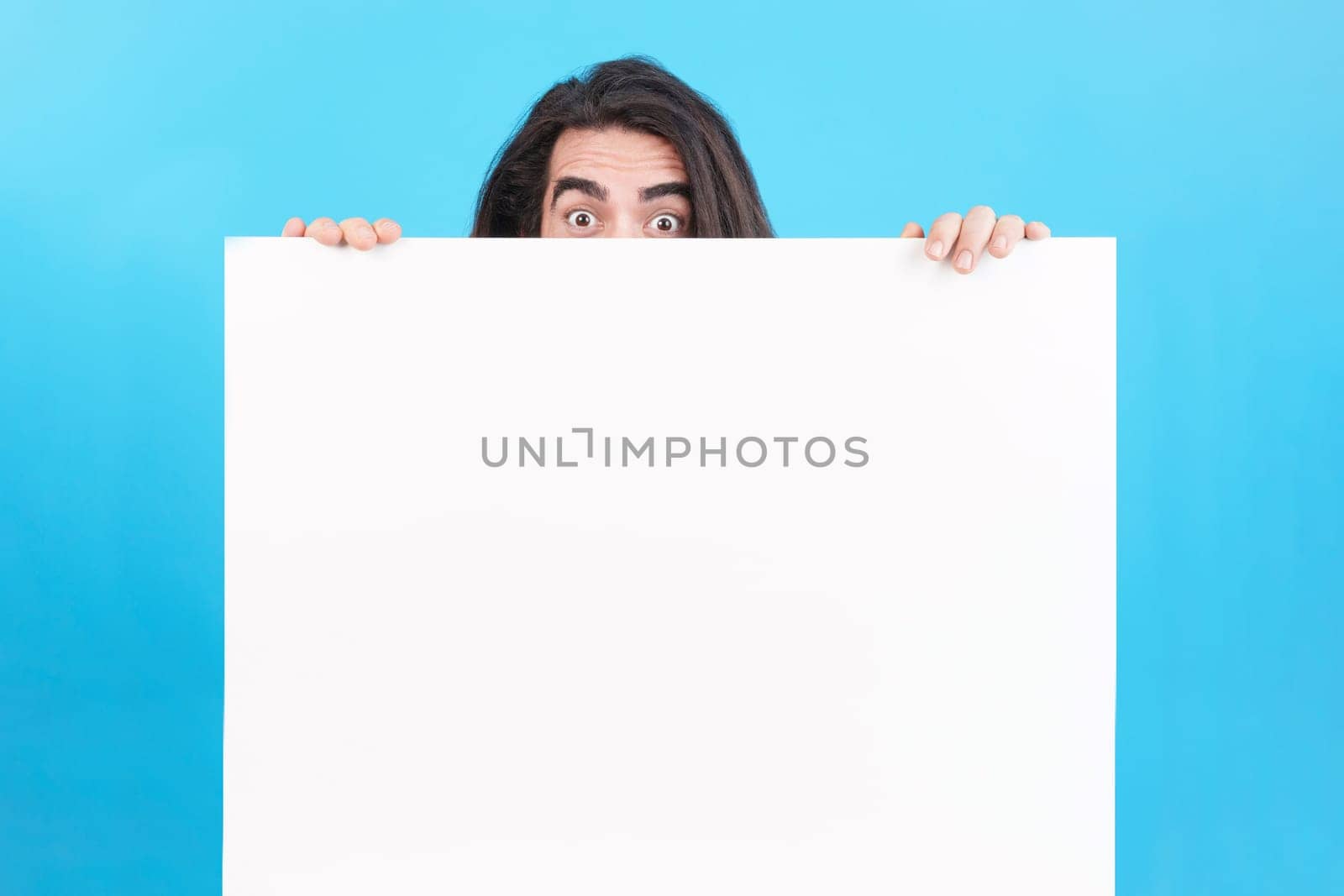 Studio portrait of a man holding a board with blank space