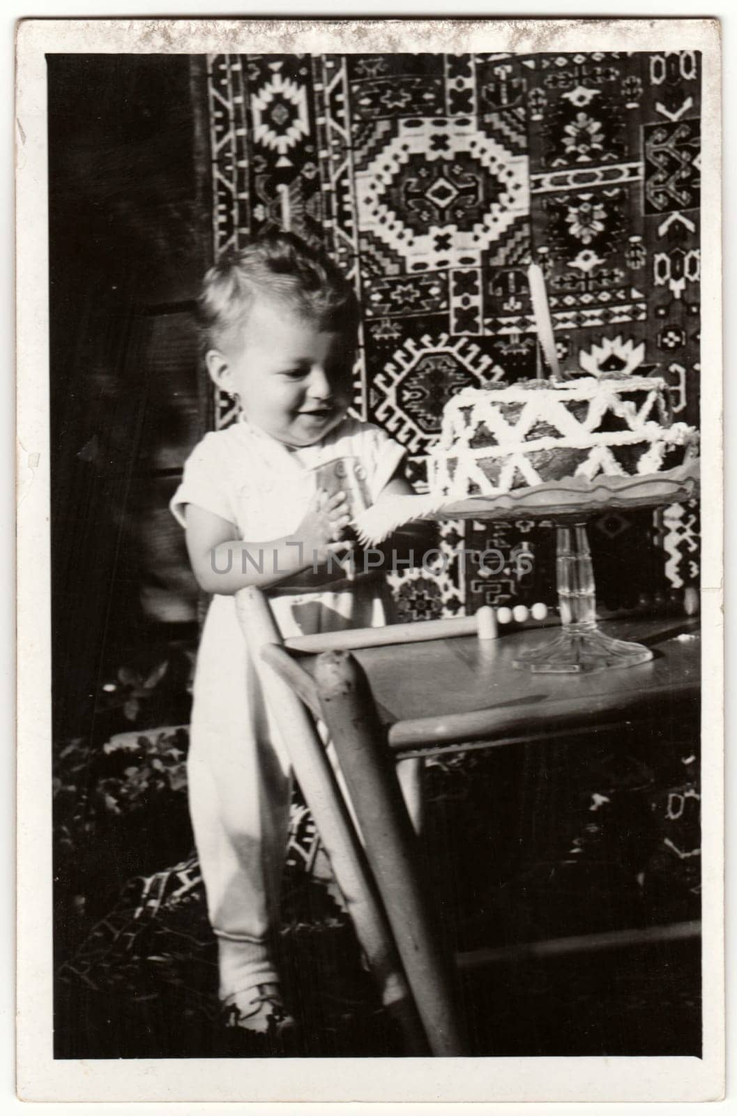 THE CZECHOSLOVAK SOCIALIST REPUBLIC - CIRCA 1960s: Vintage photo shows a boy to celebrate his first birthday. Birthday cake for boy. Retro black and white photography.